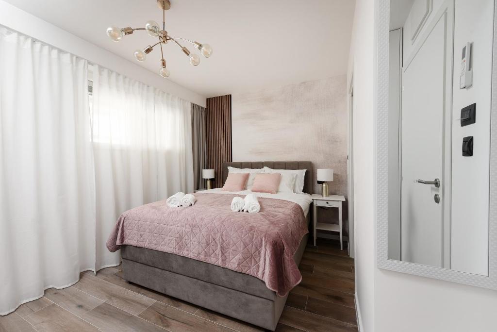 扎达尔Aura Exclusive Apartment & Room的一间卧室配有一张床,上面有两条毛巾