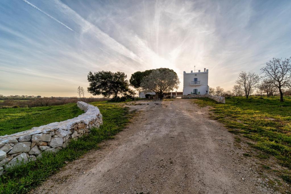 阿夸维瓦德莱丰蒂Agriturismo Tenuta del Grillaio的通往田野上白色建筑的土路