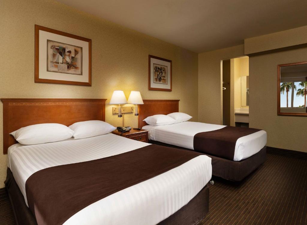 拉斯维加斯亚利桑那州查理博尔德酒店的酒店客房设有两张床和两盏灯。