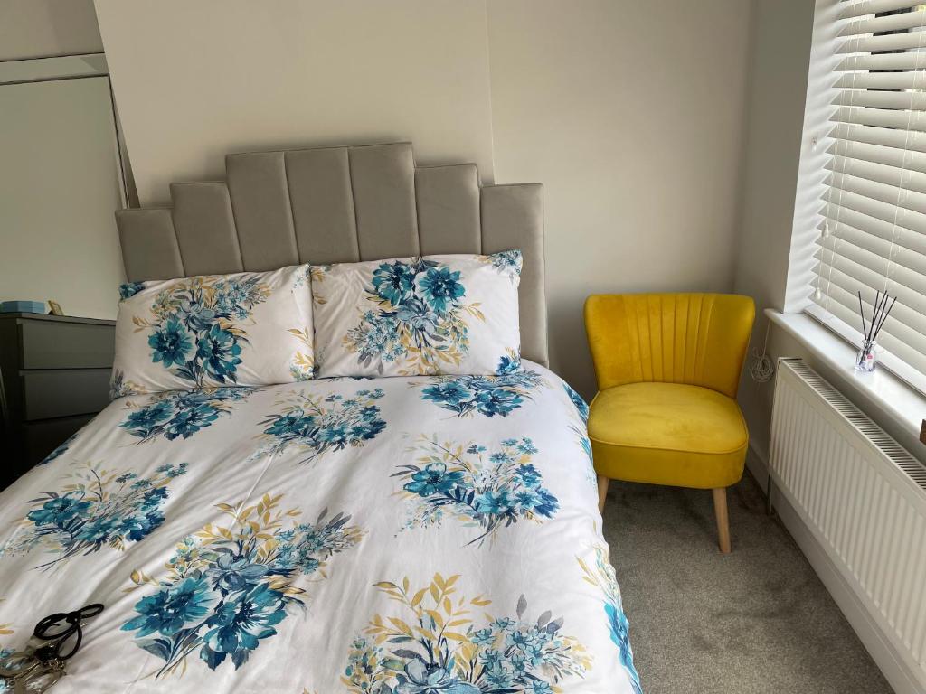 曼彻斯特Warm welcoming Home的一间卧室配有一张床和一张黄色椅子