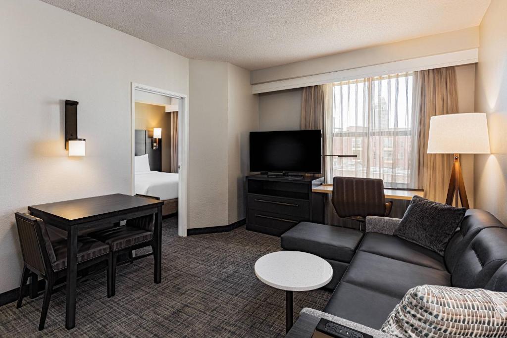 路易斯威尔路易斯维尔市中心住宅旅馆的一间客厅,客厅配有沙发和一张书桌,位于酒店的房间