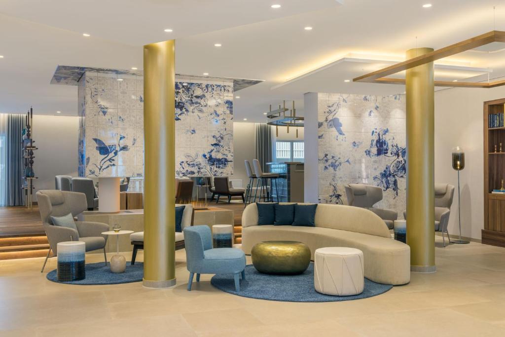 泰根塞Caro & Selig, Tegernsee, Autograph Collection的大堂拥有蓝色和白色的墙壁,配有沙发和椅子