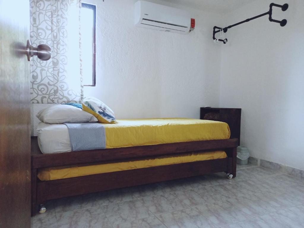 坎昆Mi Otoch en Cancun jardín terraza asador的一间卧室配有一张黄色毯子床