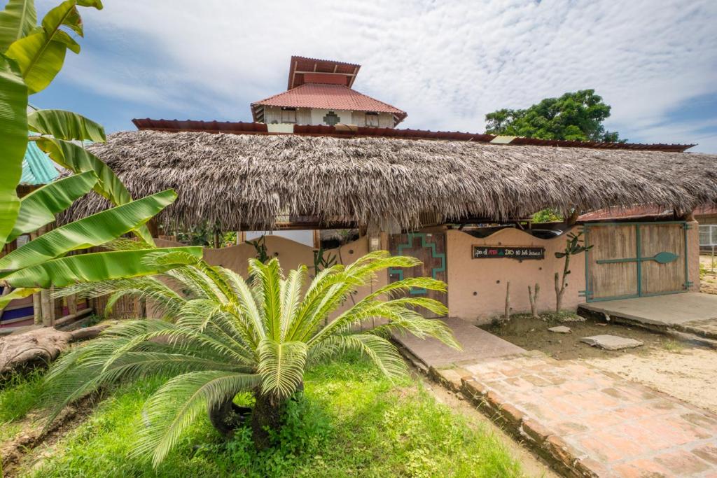 莫姆皮切Paraiso Perdido的一座带草屋顶的建筑,前面有棕榈树