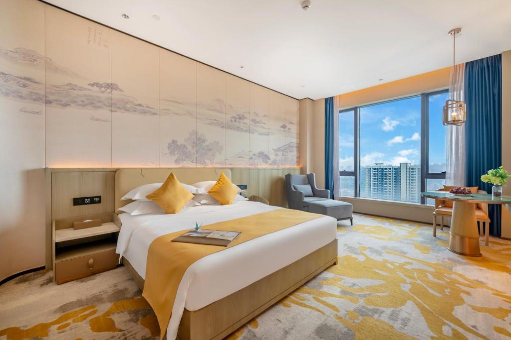 惠州惠州裕华铂金酒店的一间酒店客房,设有一张大床和一个大窗户