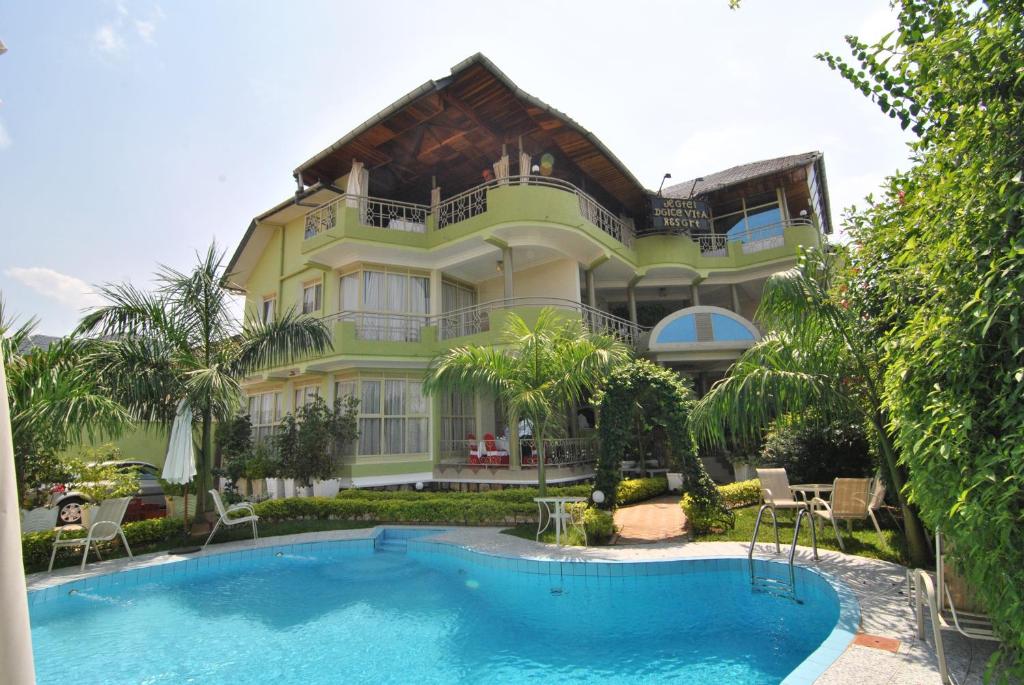 布琼布拉甜蜜生活度假酒店的一座大房子,前面设有一个游泳池