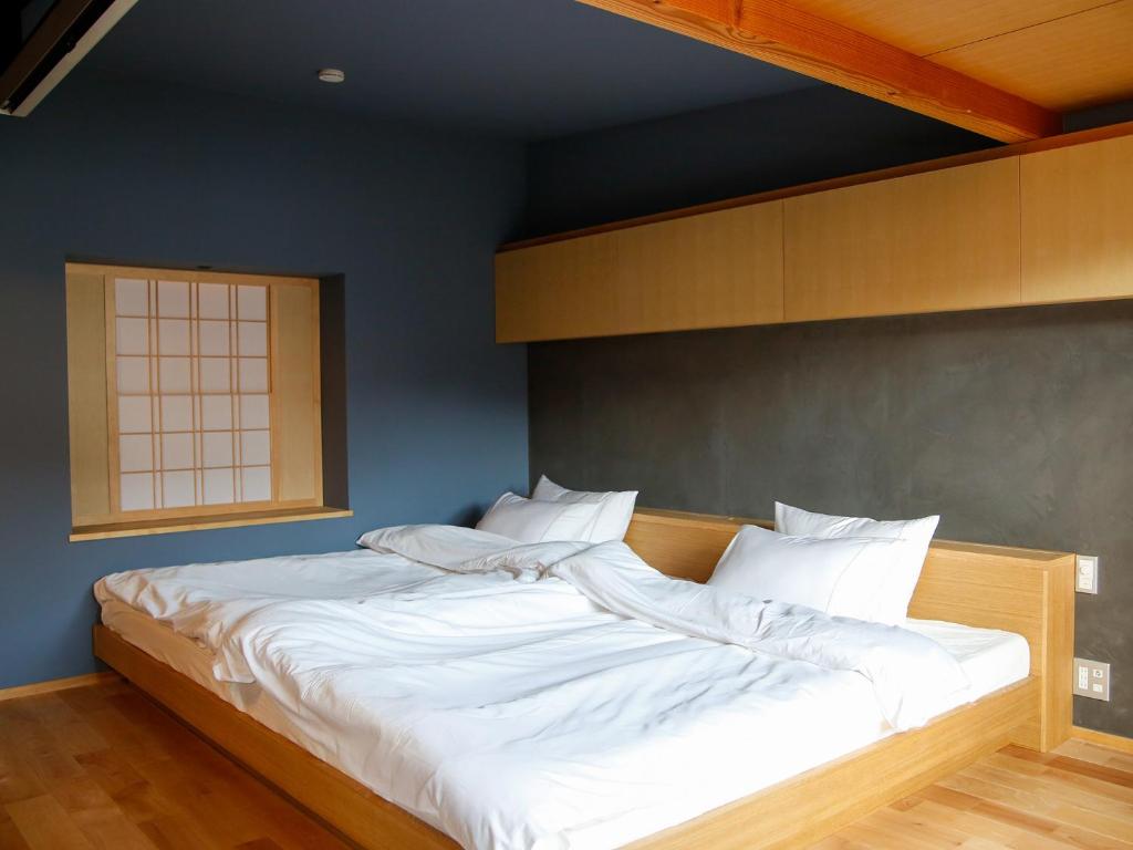 仓敷Temari Inn Madoromi的一张带白色床单和枕头的床