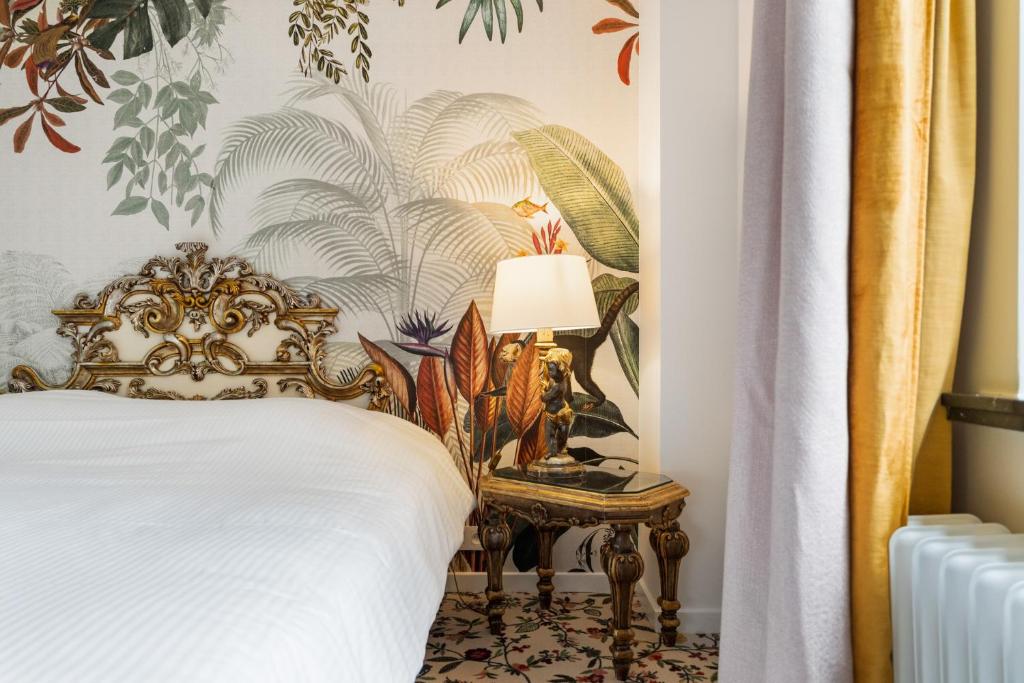 圣马尔滕斯·拉特姆托仁霍夫酒店的一间卧室配有一张床和一张带台灯的桌子