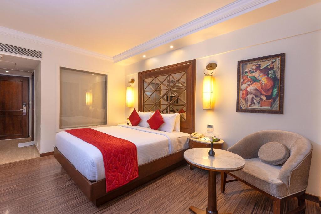 钦奈The Saibaba Hotel的配有一张床和一把椅子的酒店客房