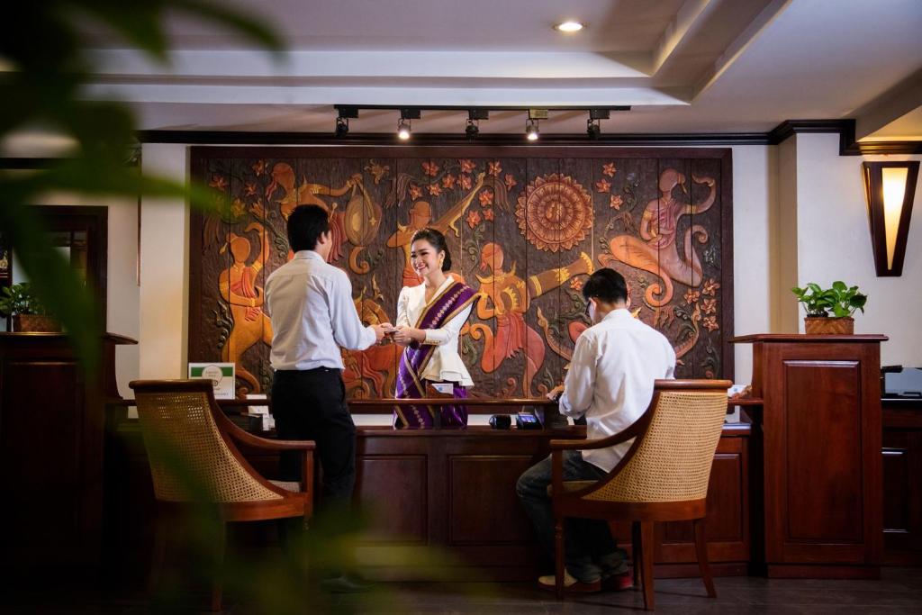 万象老挝兰花酒店 的一群人坐在餐厅酒吧里