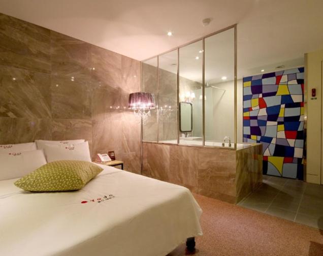蔚山Hotel H2的一间带白色大床的卧室和一间浴室