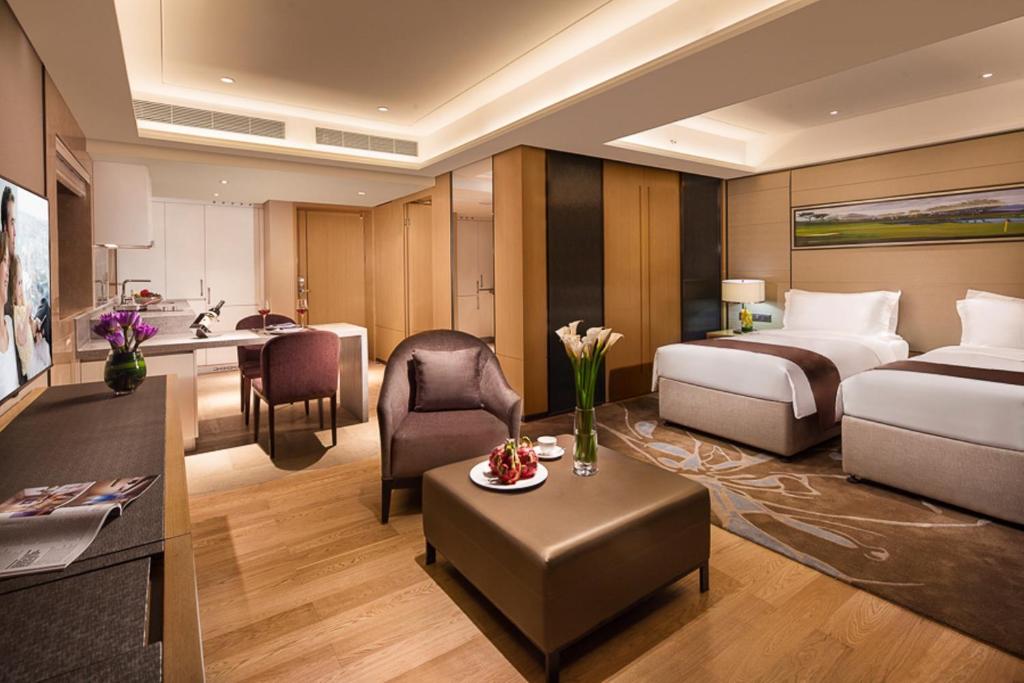 深圳深圳盛捷君临天下服务公寓的配有一张床和一张书桌的酒店客房