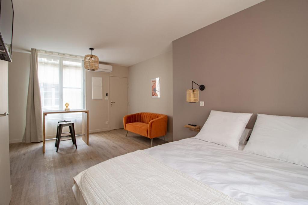 布尔日LE COURSARLON的一间卧室配有一张床、一张桌子和一把椅子