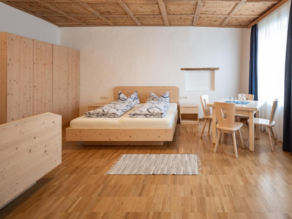 布列瑟农Vintlerhof的一间卧室配有一张床铺和一张桌子,还有一间用餐室