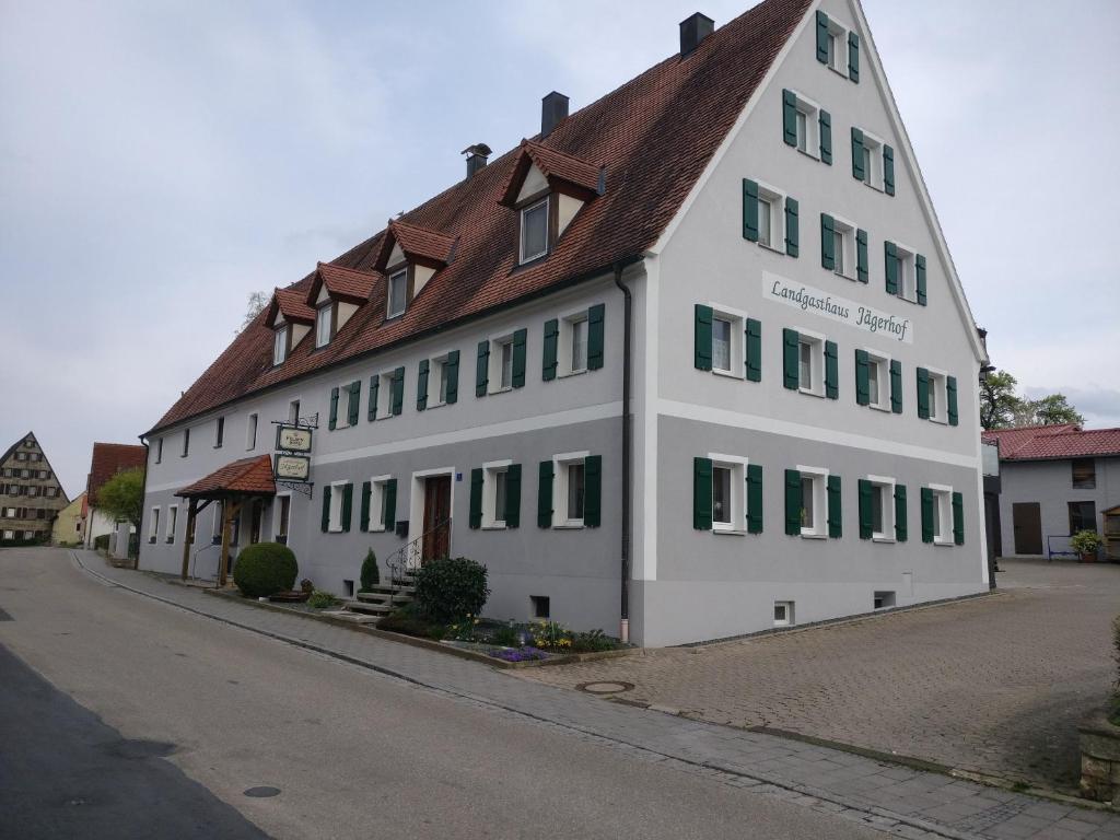 阿布斯贝格Landgasthaus Jägerhof的白色的大建筑,带有棕色的屋顶