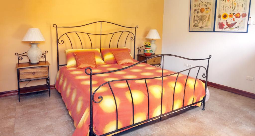 三百岭西班牙别墅的一间卧室配有一张带橙色棉被的床