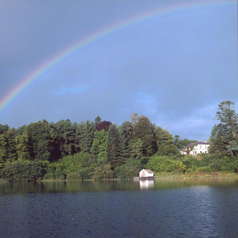 乌特拉德卡洛拉维埃克酒店的湖上的一个彩虹,有房子和船