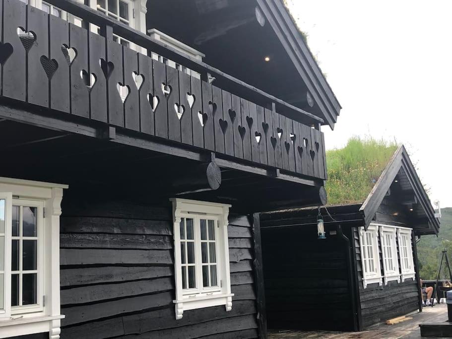 KvamNydelig hytte på Kvamskogen, nær Hardangerfjorden的一座木制建筑,上面设有一个阳台