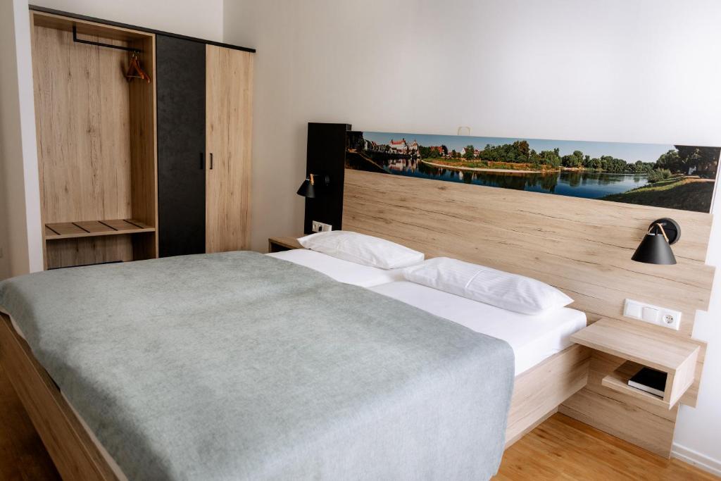 多瑙河畔诺伊堡埃姆夫鲁斯酒店的一间卧室设有一张大床和大窗户