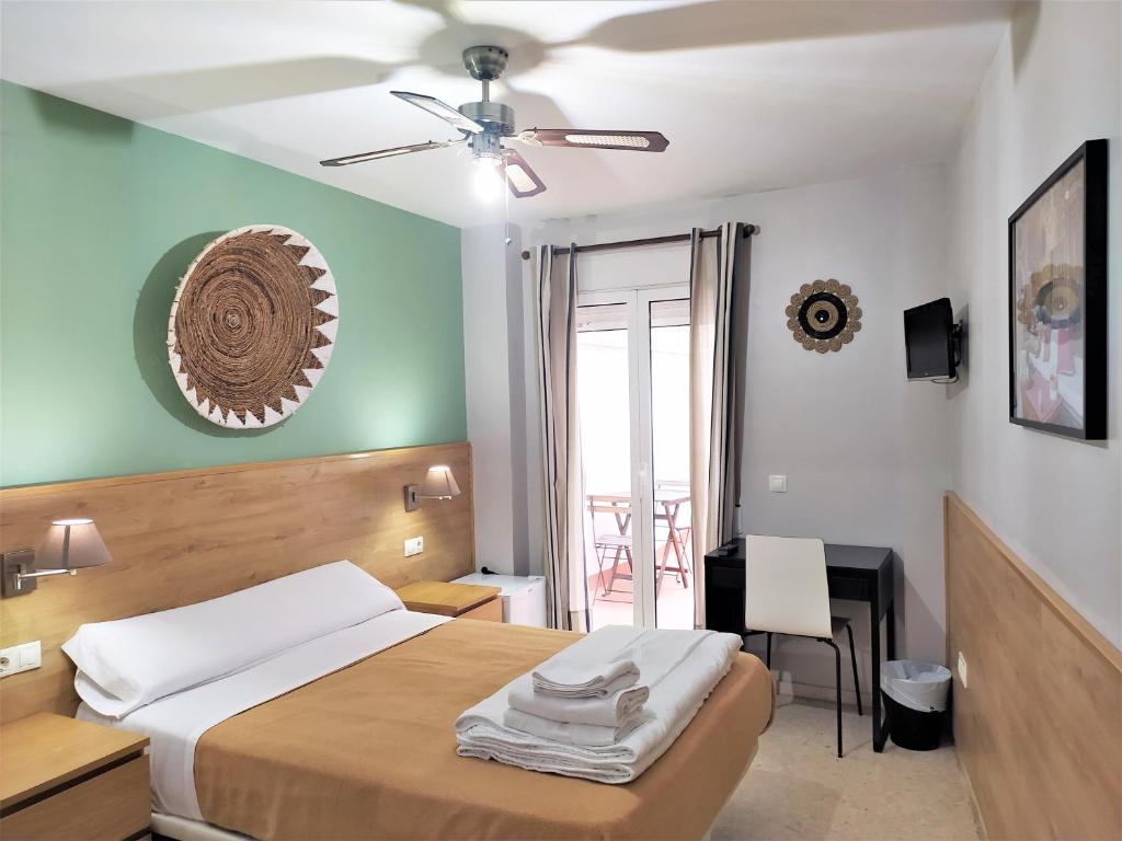 瓦伦西亚Habitaciones Barra89的一间卧室配有一张带吊扇的床