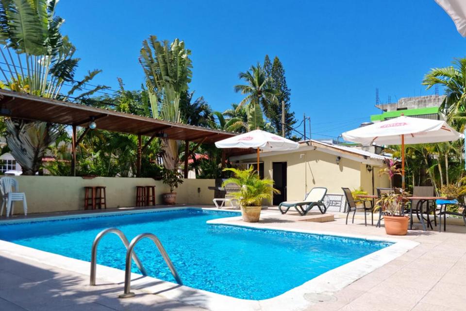 苏莎亚唐安德烈斯酒店的一个带桌椅和遮阳伞的游泳池
