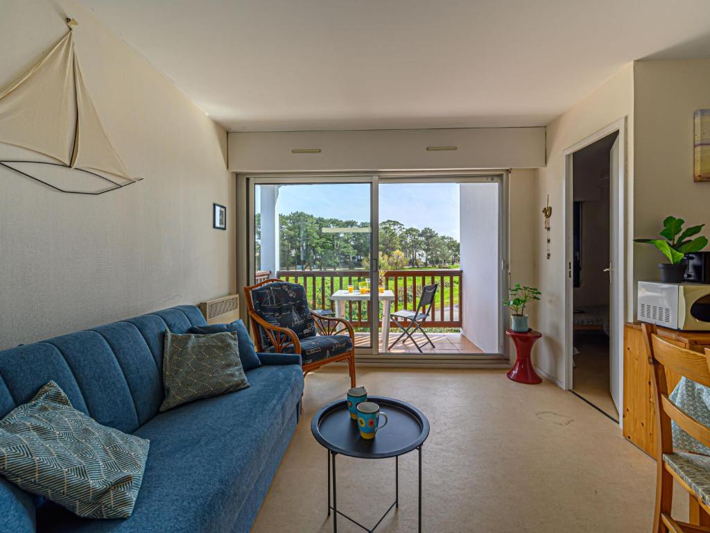 卡纳克海滩Apartment Plein Ciel-1 by Interhome的一间带蓝色沙发的客厅和一个阳台