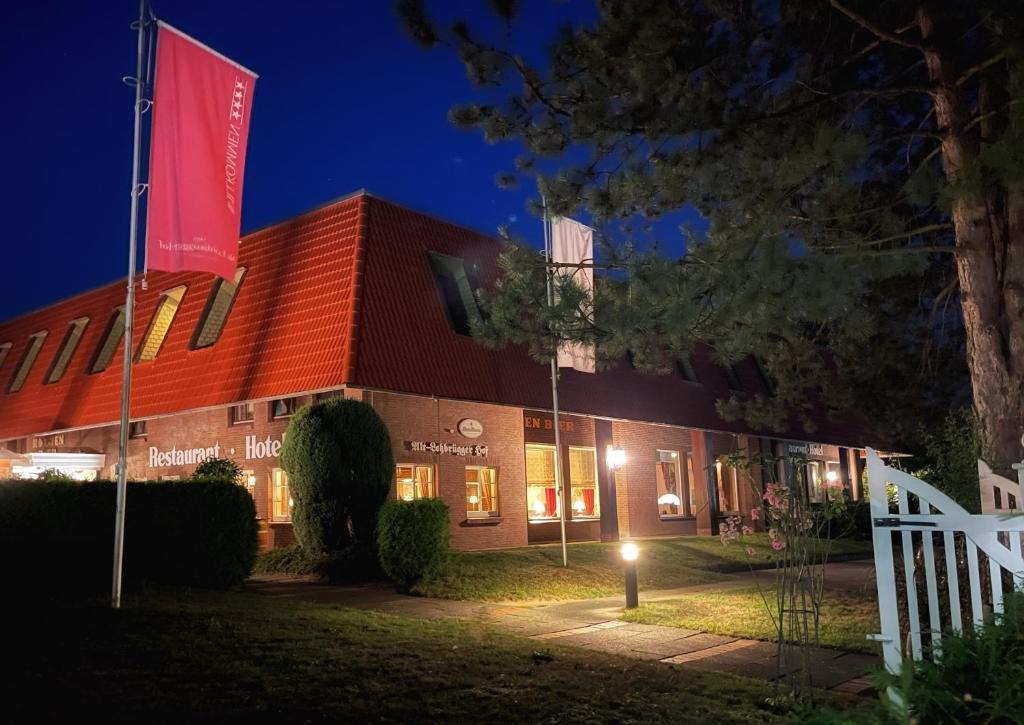 汉堡阿尔特罗布鲁格霍夫酒店的一座晚上有红旗的建筑