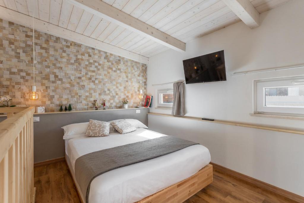 夸尔图-圣埃莱娜Loft 35 - private parking的卧室配有一张床,墙上配有电视。