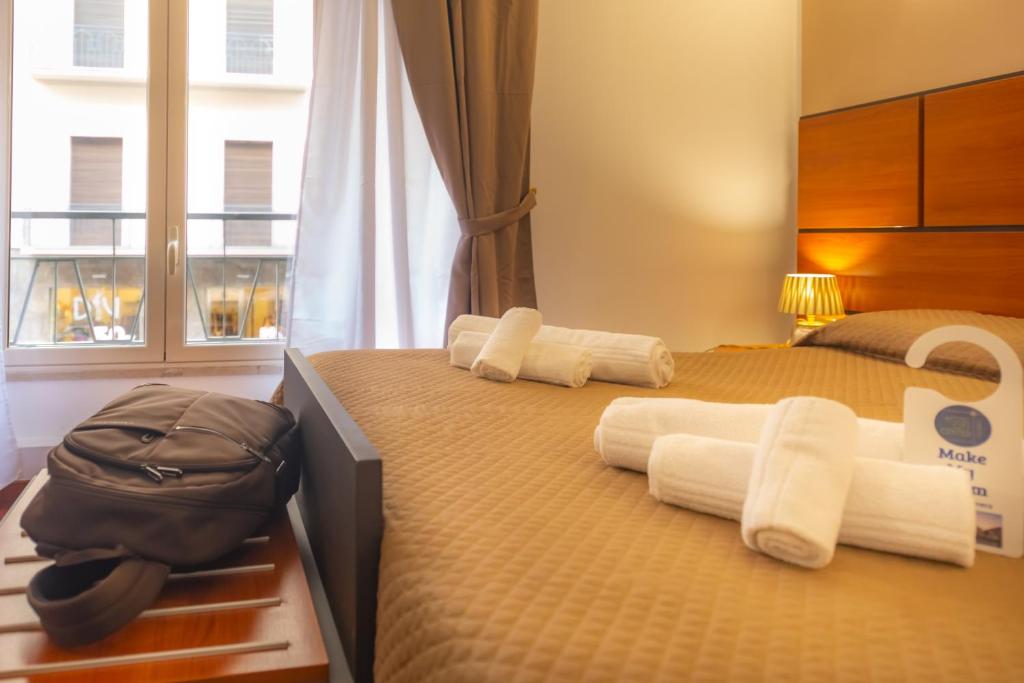 巴勒莫Hotel City Center的一间卧室配有两张床、毛巾和袋子