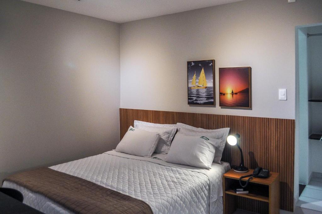 累西腓Suites Residence的一间卧室配有一张床和一个带灯的床头柜