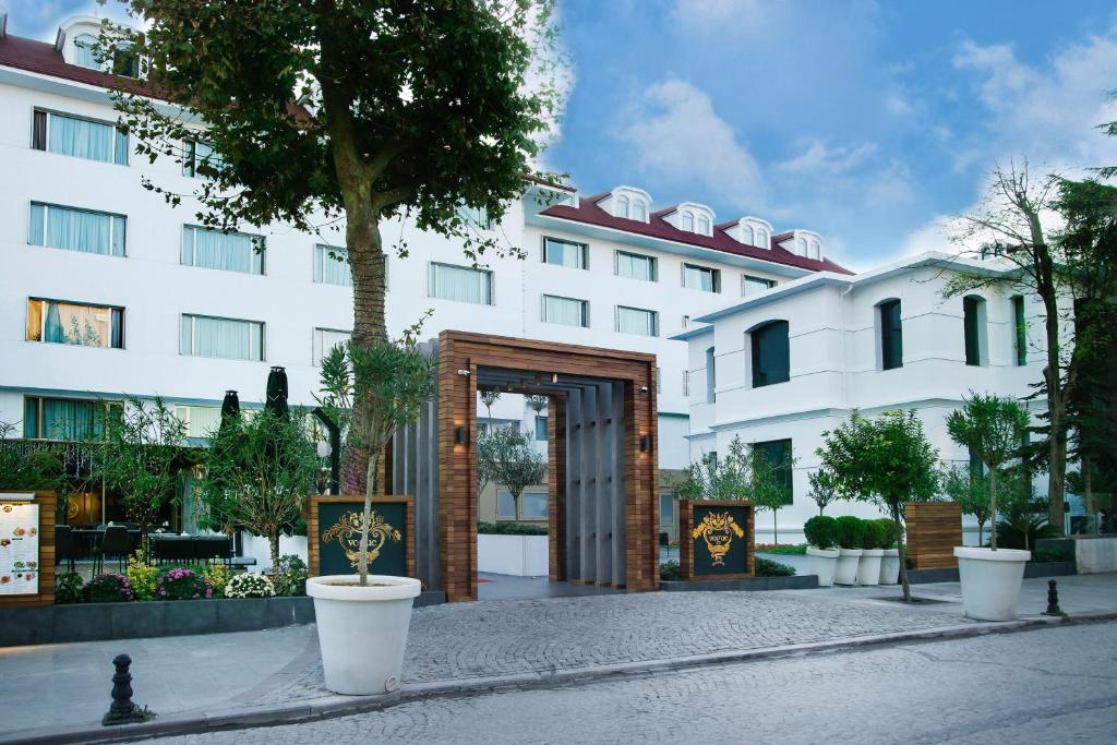伊斯坦布尔Vogue Hotel Supreme Istanbul的一座白色的大建筑,前面设有木门
