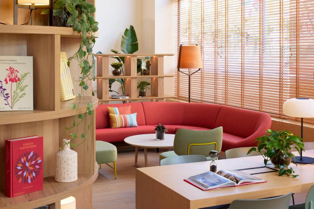 巴塞罗那INNSiDE by Meliá Barcelona Apolo的客厅配有红色的沙发和桌子