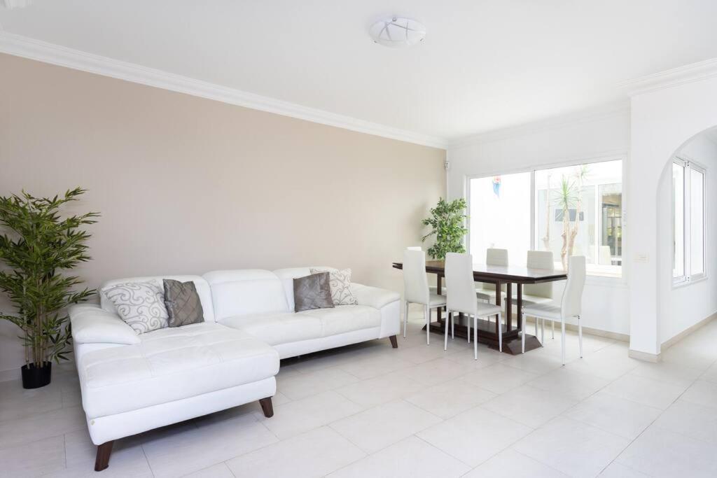 阿德耶Villa esclusiva a 300m da Playa del Duque的白色的客厅配有白色的沙发和桌子
