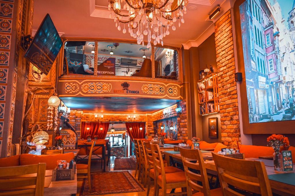伊斯坦布尔Ethnica Hotel Old City的一间带桌椅和吊灯的餐厅