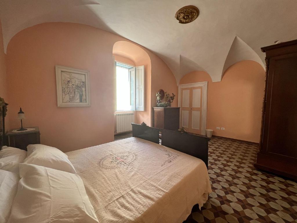 卢切拉B&B Palazzo Lombardi的一间卧室设有一张大床和一个窗户。