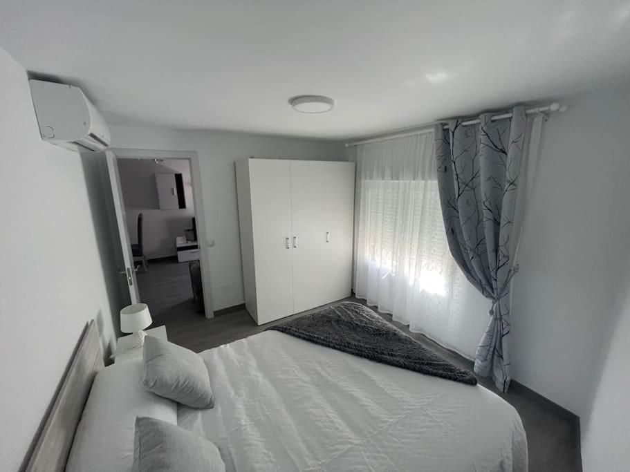 托雷洪-德阿尔多斯Tu precioso piso en el centro de Torrejón的卧室配有白色的床和窗户。