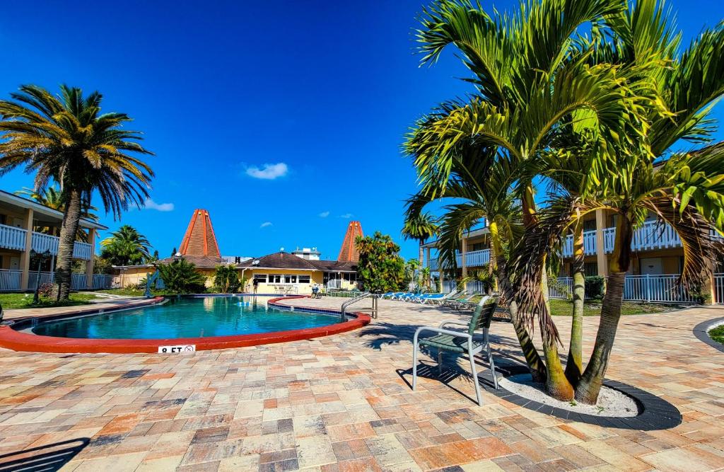 霍勒迪Holiday Hotel的度假村内棕榈树游泳池