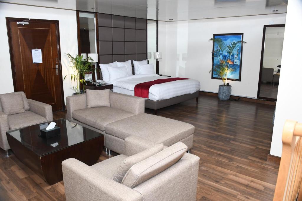 伊斯兰堡Rockville House managed & operated by Serai Boutique Hotels and Resorts的酒店客房配有一张床、一张沙发和椅子。