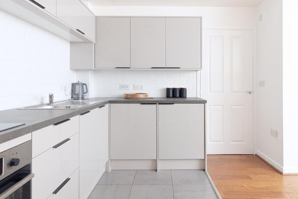 伯明翰Luxury Apartment, Birmingham-Parking的白色的厨房配有白色橱柜和水槽