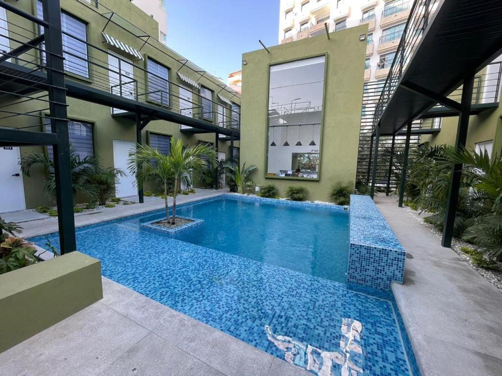 圣玛尔塔OASIS TROPICAL HOTEL的一座建筑物中央的游泳池