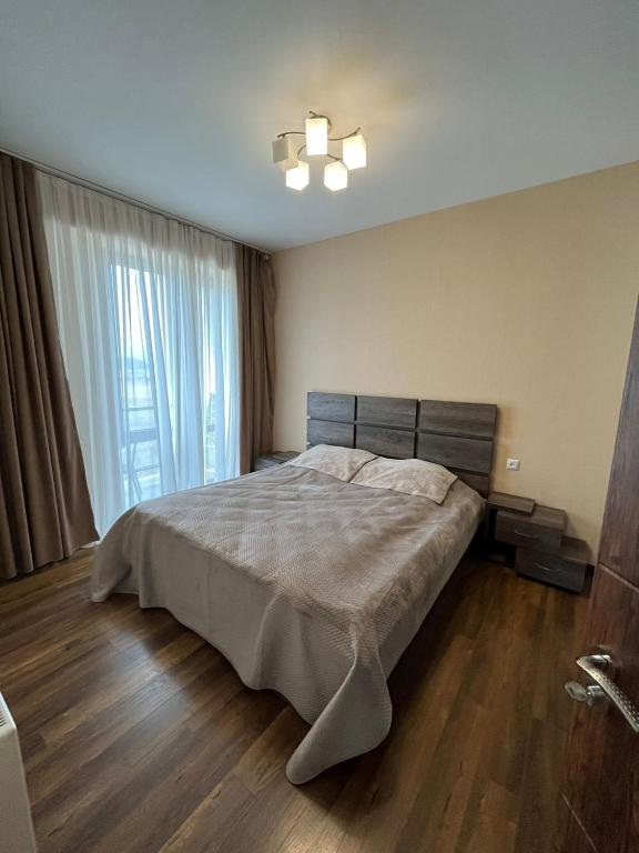 巴库里阿尼Villa Deluxe Premium Apartment 308的一间卧室设有一张床和一个大窗户