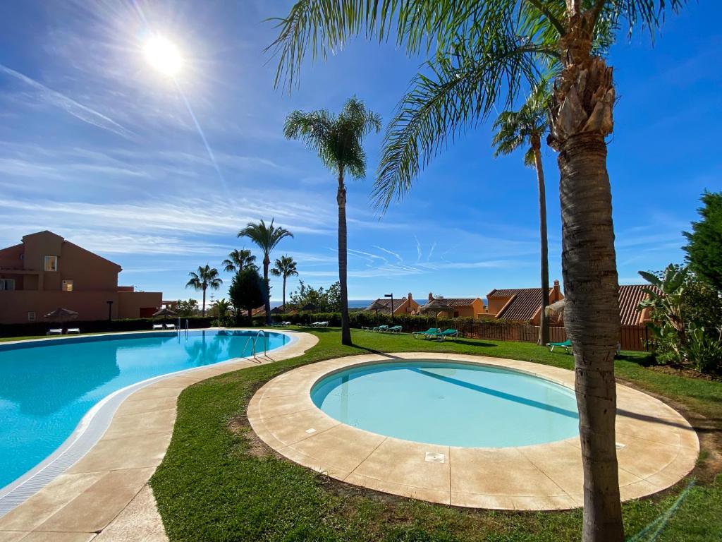 马贝拉Marbella Elviria apartment的周围环绕棕榈树的游泳池