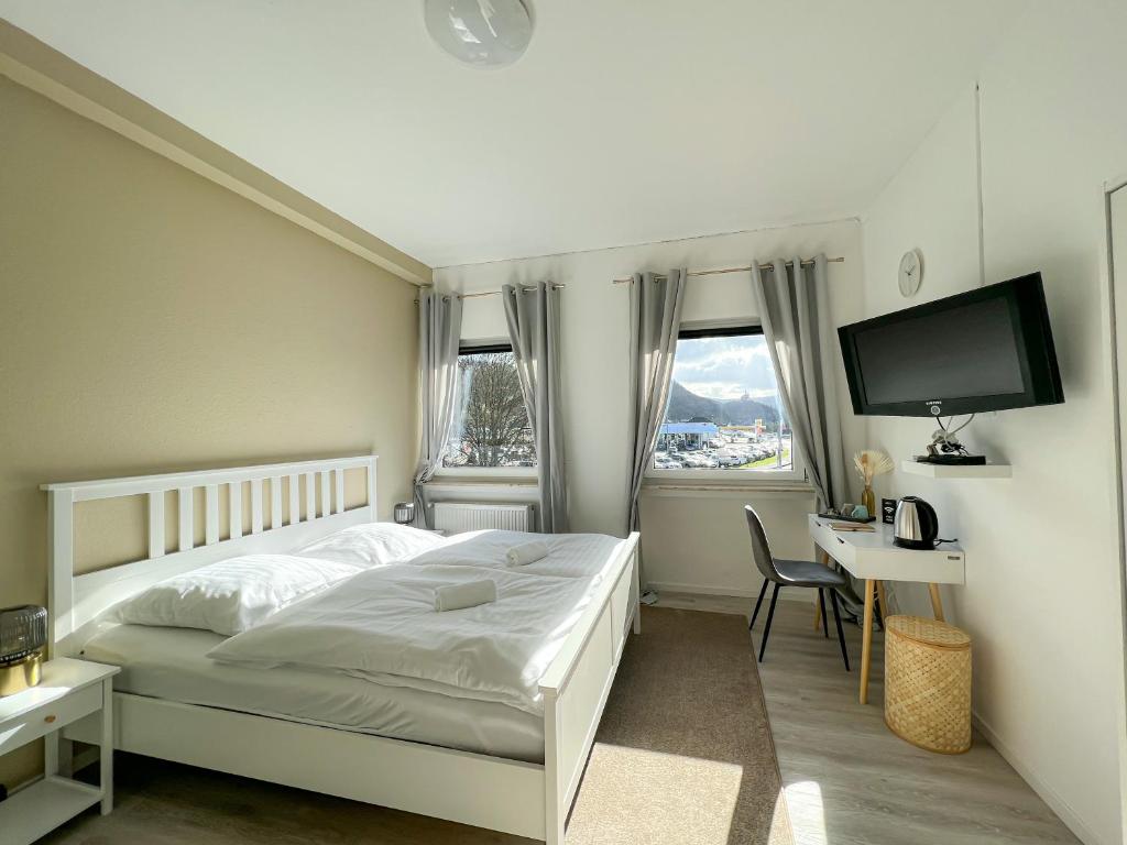 兰施泰因Magaré Hotel & Restaurant的一间卧室配有一张床、一张书桌和一台电视