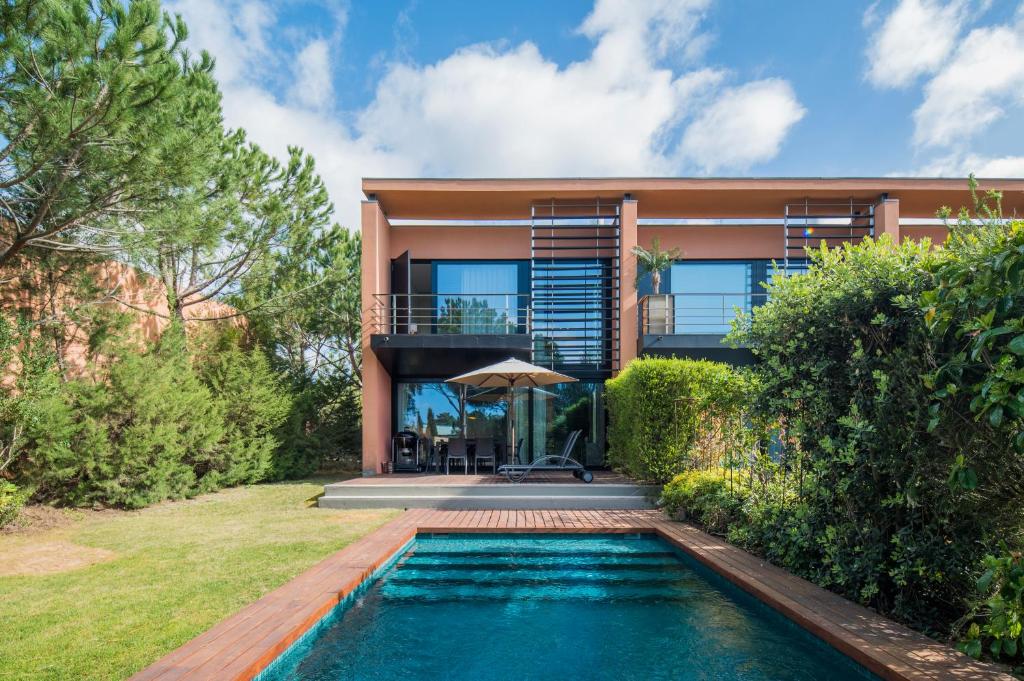 特罗亚Tróia Resort Beach Villa的房屋前有游泳池的房子