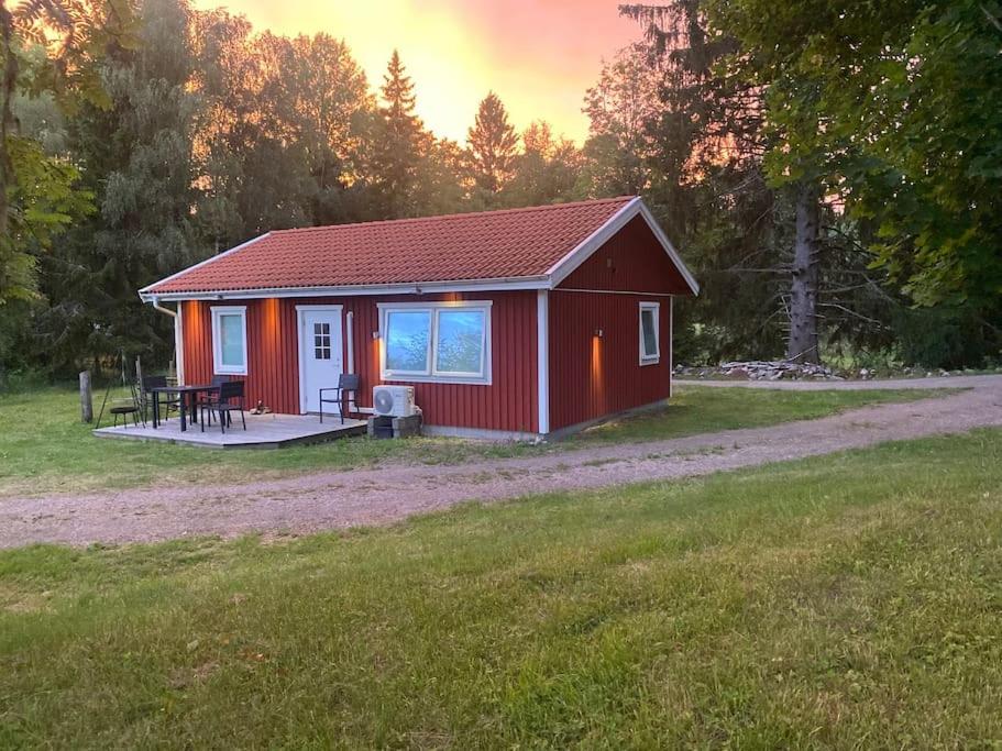 布罗斯Gästhus i Borås (Guest House)的红色小屋,在田野上设有门廊