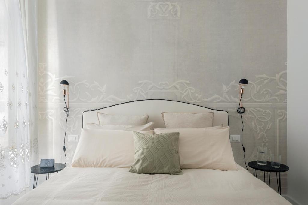 巴勒莫Palazzo Ventimiglia的卧室内的一张带白色床单和枕头的床