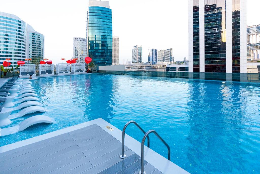 迪拜Lux Studio in Downtown, 5 mins to Burj Khalifa & Dubai Mall - MAG318的一座高楼建筑顶部的游泳池