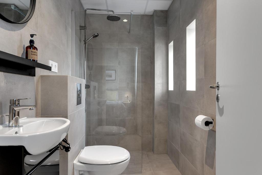 雷克雅未克NN Urban Guesthouse的浴室配有卫生间、盥洗盆和淋浴。