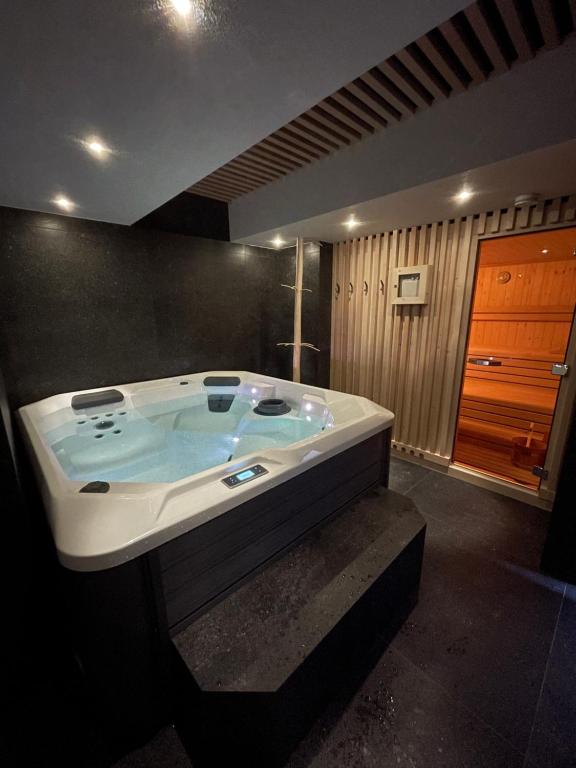 迪马罗Dolomia Apartments & Spa的客房内的浴室设有大浴缸