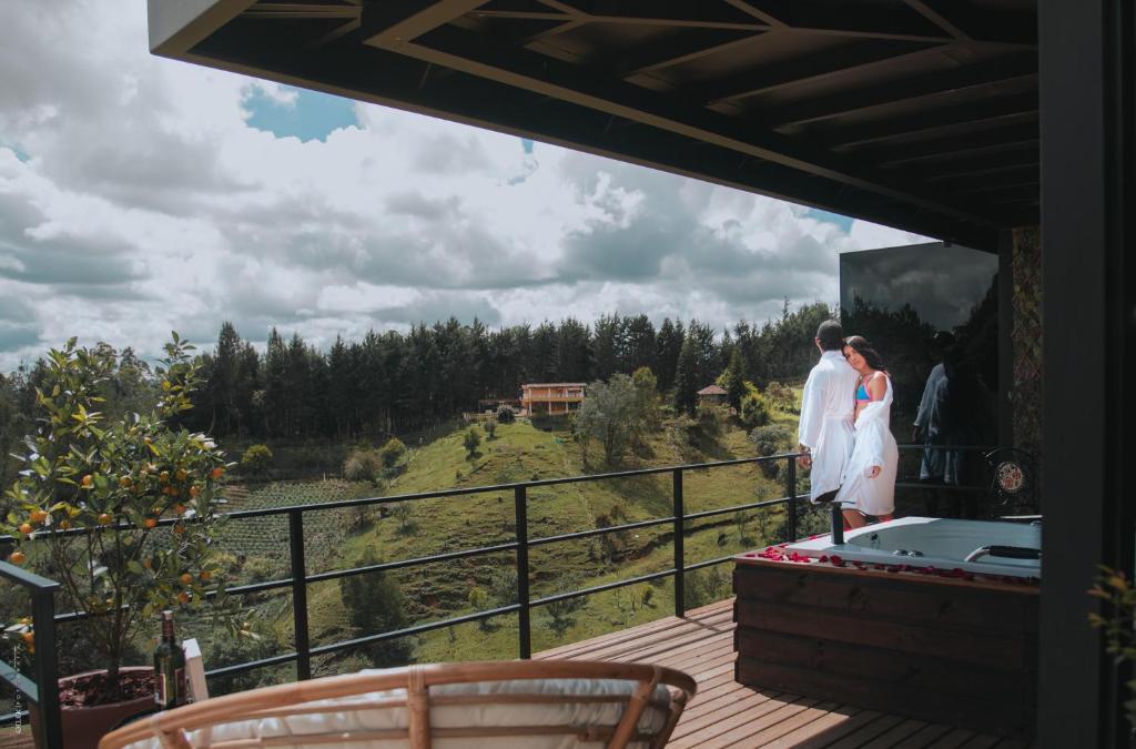 瓜尔内Cumbres Luxury Glamping的站在房子阳台上的新娘和新郎